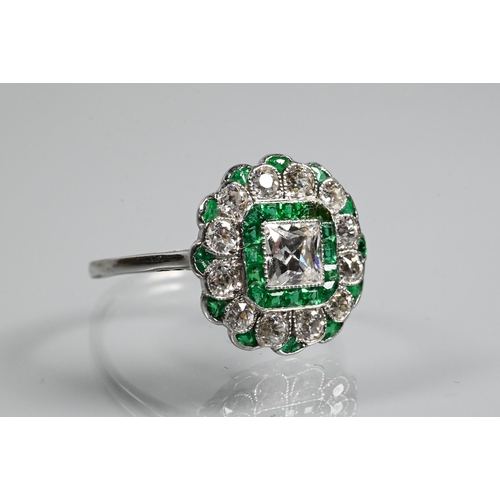 328 - An Art Deco cluster ring, the central assher cut diamond surrounded by a band of square cut emeralds... 