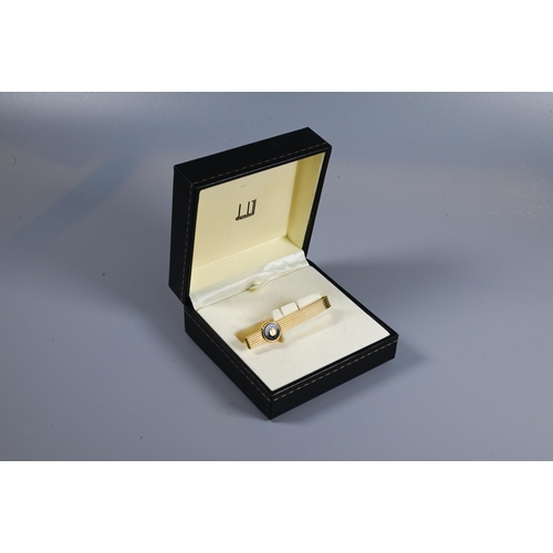 346 - A gilt metal tie tack by Dunhill, in fitted box