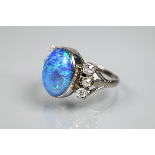 352 - An opal and diamond ring, the large opal of blue iridescence with three diamonds to each side, white... 