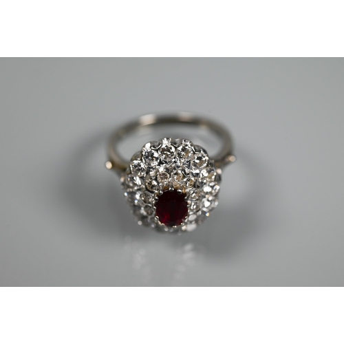 364 - A diamond ruby cluster ring, the oval two row diamond cluster supporting an oval ruby in high claw s... 