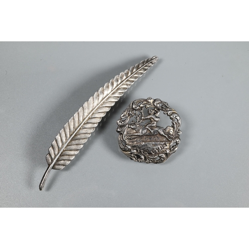 370 - A white metal brooch in the form of a feather, 9.5 cm long, stamped silver; a Peer Gynt brooch stamp... 