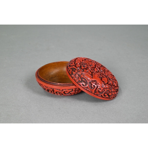 422 - A 20th century Chinese cinnabar style circular box and cover, moulded with a floral and foliate desi... 