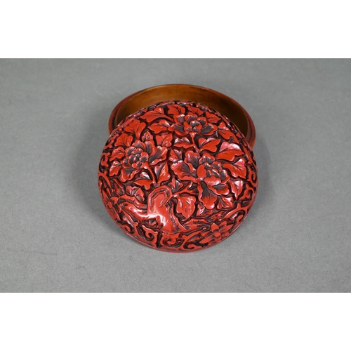 422 - A 20th century Chinese cinnabar style circular box and cover, moulded with a floral and foliate desi... 