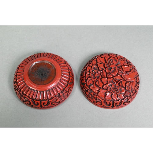 422 - A 20th century Chinese cinnabar style circular box and cover, moulded with a floral and foliate desi... 