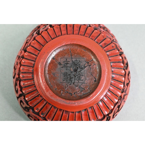 422 - A 20th century Chinese cinnabar style circular box and cover, moulded with a floral and foliate desi... 