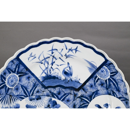 436 - A 19th century Japanese blue and white floriform charger, painted with a goose and bamboo within a f... 