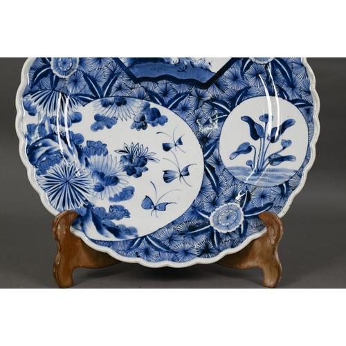 436 - A 19th century Japanese blue and white floriform charger, painted with a goose and bamboo within a f... 