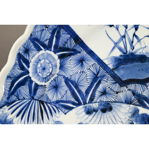 436 - A 19th century Japanese blue and white floriform charger, painted with a goose and bamboo within a f... 