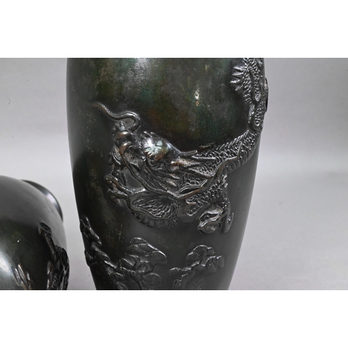 448 - A pair of Japanese base metal vases cast in high relief with fierce three-clawed dragons, simulated ... 