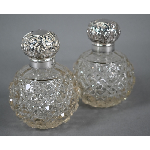45 - Pair of Edwardian cut glass globular scent bottles with embossed silver screw bun covers, Birmingham... 