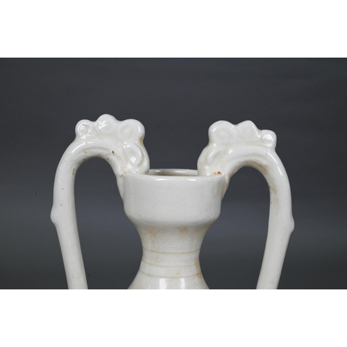 452 - A Chinese Tang style white glazed 'amphora' vase, the looping handles with dragon head terminals bit... 