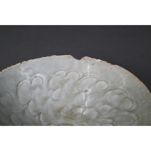 453 - A Chinese Qingbai bowl, Song Dynasty (960-1279) with incised cloud motif design under the pale celad... 