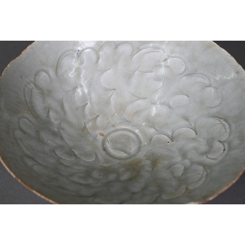 453 - A Chinese Qingbai bowl, Song Dynasty (960-1279) with incised cloud motif design under the pale celad... 