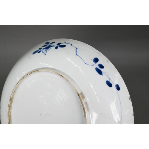 463 - A 18th/19th century Chinese blue and white shallow bowl, painted in underglaze blue with flowers wit... 