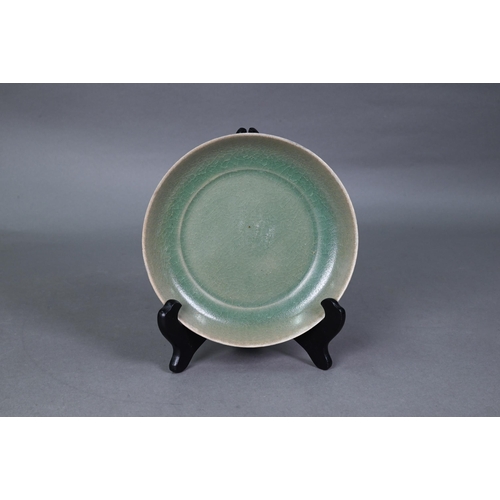 465 - A Chinese celadon dish with combed exterior, covered in a crackled olive green glaze thinning in col... 