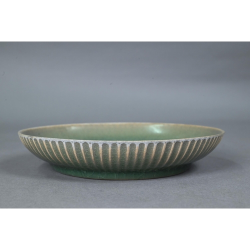 465 - A Chinese celadon dish with combed exterior, covered in a crackled olive green glaze thinning in col... 