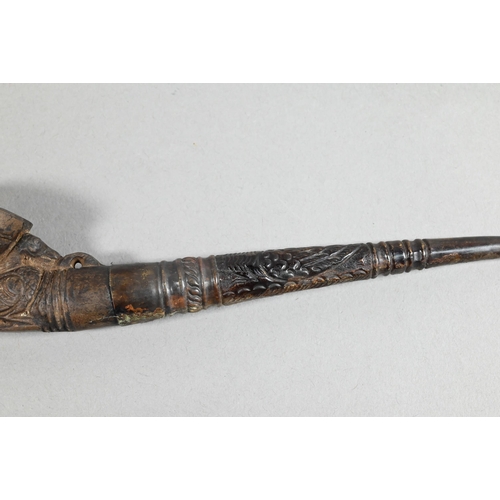 473 - An antique Tibetan Buddhist ritual pipe with moulded clay bowl inserted into the long embossed coppe... 