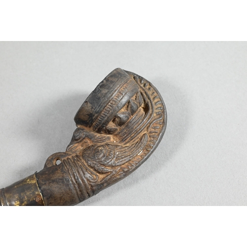 473 - An antique Tibetan Buddhist ritual pipe with moulded clay bowl inserted into the long embossed coppe... 