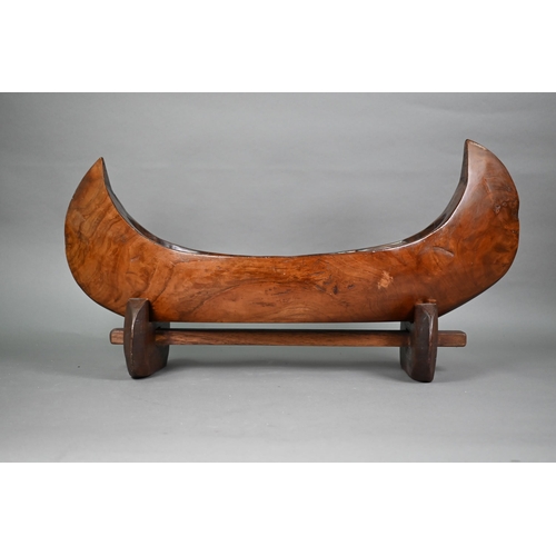 491 - An Indonesian stained and hollowed hardwood fruit bowl on stand in the form of a dugout canoe, 65 cm... 