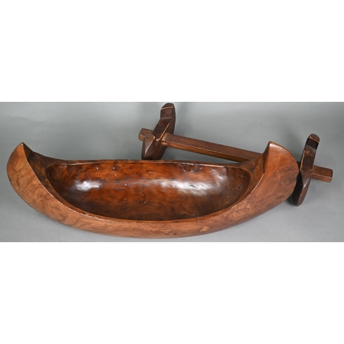 491 - An Indonesian stained and hollowed hardwood fruit bowl on stand in the form of a dugout canoe, 65 cm... 