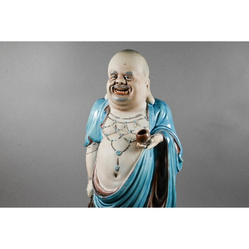 494 - A 20th century Chinese part-glazed bisque porcelain figure of Budai Hehang (Laughing Buddha) modelle... 