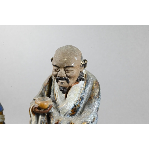 496 - Three early 20th century Chinese Shiwan bique porcelain part-glazed figures of elders holding variou... 