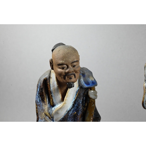 496 - Three early 20th century Chinese Shiwan bique porcelain part-glazed figures of elders holding variou... 