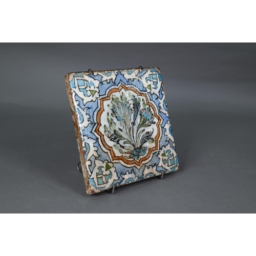 497 - An Ottoman Iznik fritware tile, painted with Islamic floral designs in polychrome enamels under the ... 