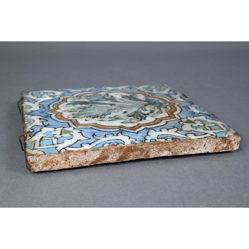 497 - An Ottoman Iznik fritware tile, painted with Islamic floral designs in polychrome enamels under the ... 