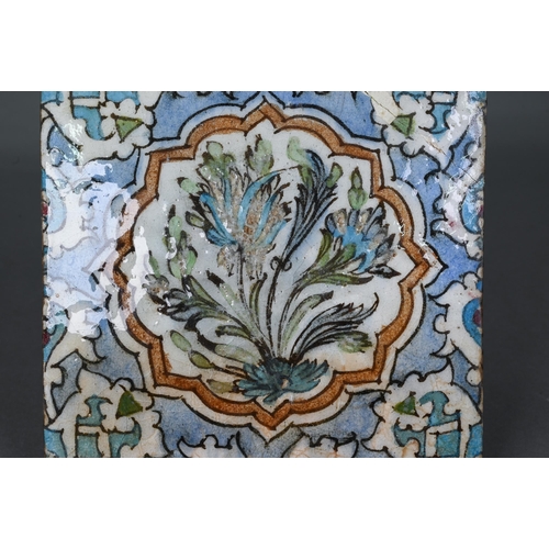 497 - An Ottoman Iznik fritware tile, painted with Islamic floral designs in polychrome enamels under the ... 