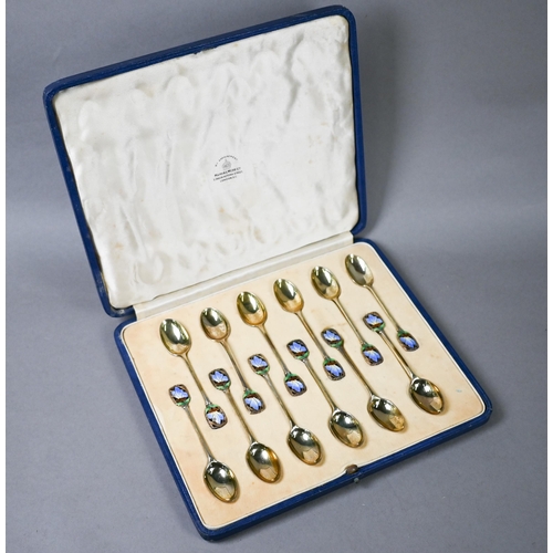 68 - Cased set of twelve Art Deco silver gilt coffee spoons with finials pierced and enamelled with butte... 