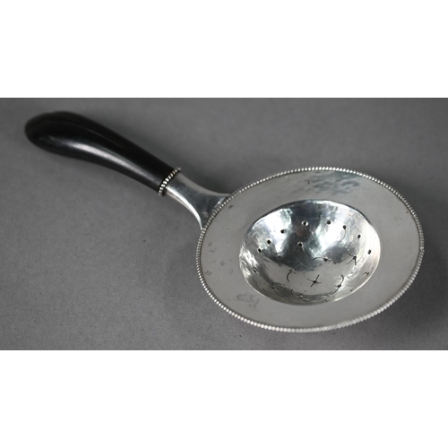 9 - Danish unmarked white metal tea strainer with beaded rim and ebonised carved handle, 17cm long