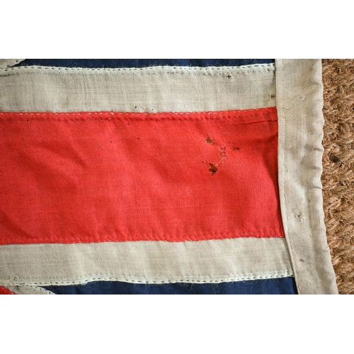 1199 - A WWII period Royal Navy ensign, of stitched panels with 'union jack' to top corner, stencilled 'C W... 