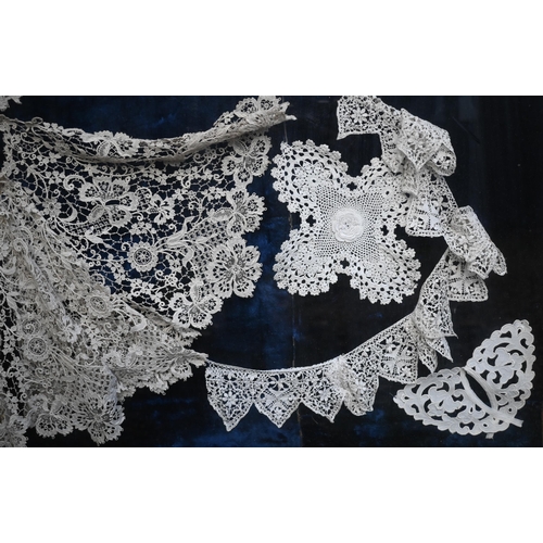 1284 - A framed collection of antique lace fringings, trimmings, collars, lace-edged handkerchief, and a ne... 