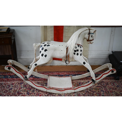 1288 - An antique painted pine rocking horse with glass eyes and leather fittings, on rocker, overpainted a... 