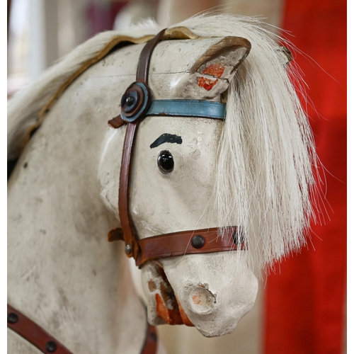 1288 - An antique painted pine rocking horse with glass eyes and leather fittings, on rocker, overpainted a... 