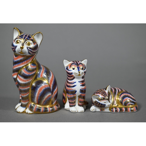 565 - Three Royal Crown Derby china cat paperweights, 13-4 cm to/w a miniature teapot (4)