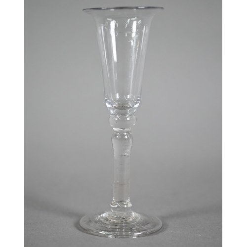 640 - A Georgian drinking glass, the elongated bowl with flared rim, on baluster stem with folded foot-rim... 