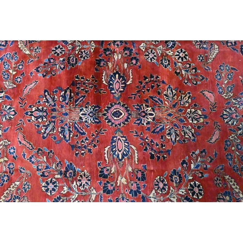 808 - An antique Persian Mohajeran - Sarouk carpet, the dark salmon ground with overall floral design, 353... 