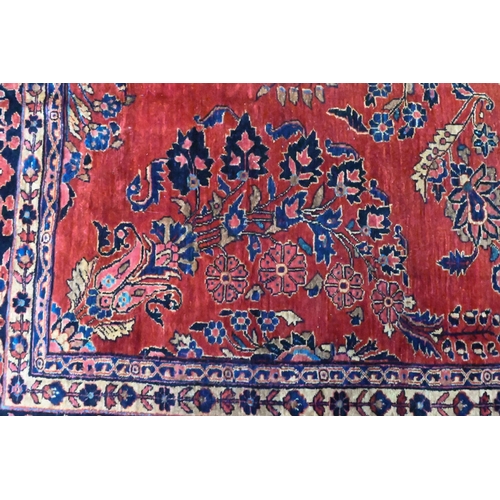 808 - An antique Persian Mohajeran - Sarouk carpet, the dark salmon ground with overall floral design, 353... 