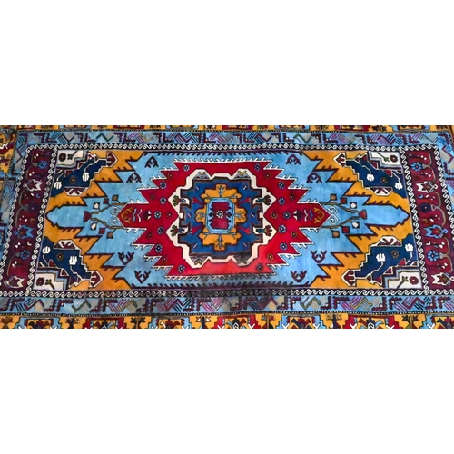 809 - A Turkish light blue ground rug with centred with gold ground lozenge design, 234 cm x 132 cm