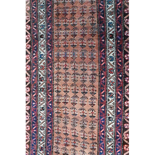 814 - An antique Persian Hamadan runner, the pale red ground with repeating stylised floral design, first ... 