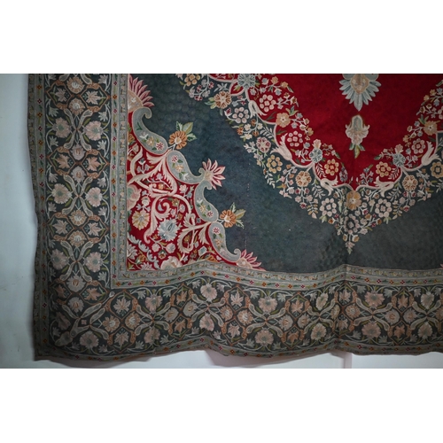 822 - A large antique Kashmir crewel work carpet, first quarter 20th century, the soft red ground with sty... 