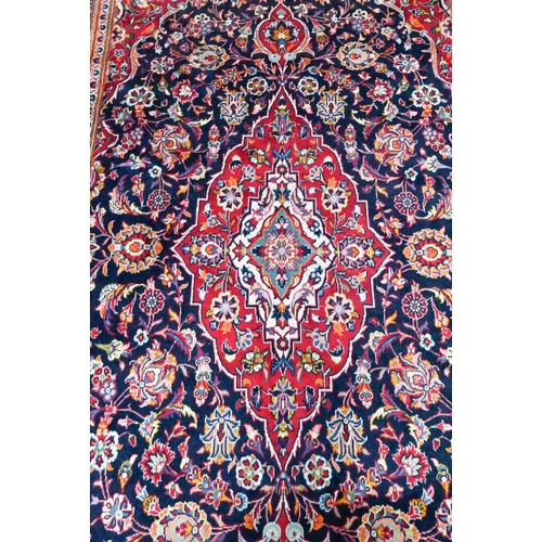 823 - A contemporary central Persian Kashan carpet, the blue and red ground centred by a floral medallion,... 