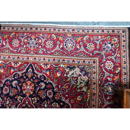 823 - A contemporary central Persian Kashan carpet, the blue and red ground centred by a floral medallion,... 