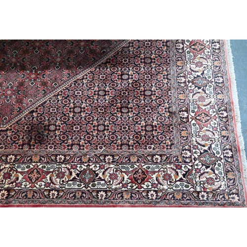 824 - A Persian Bidjar red ground carpet, centred by a diamond floral lozenge, 335 cm x 247 cm