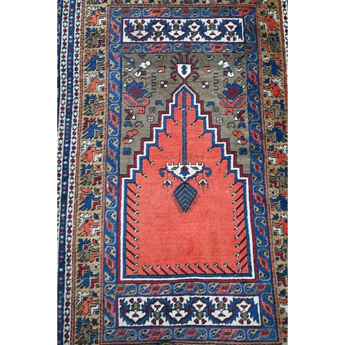 828 - A contemporary Turkish prayer design rug, the coral ground centre panel flanked by stylised floral d... 