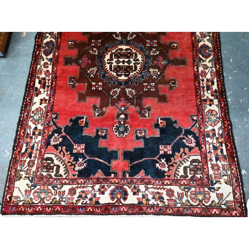 829 - A contemporary North West Persian Tafresh rug, the brown-red ground with stylised floral medallion, ... 