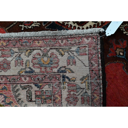 829 - A contemporary North West Persian Tafresh rug, the brown-red ground with stylised floral medallion, ... 