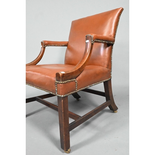 852 - An antique mahogany Gainsborough style library elbow chair, with studded brown leather upholstery, r... 